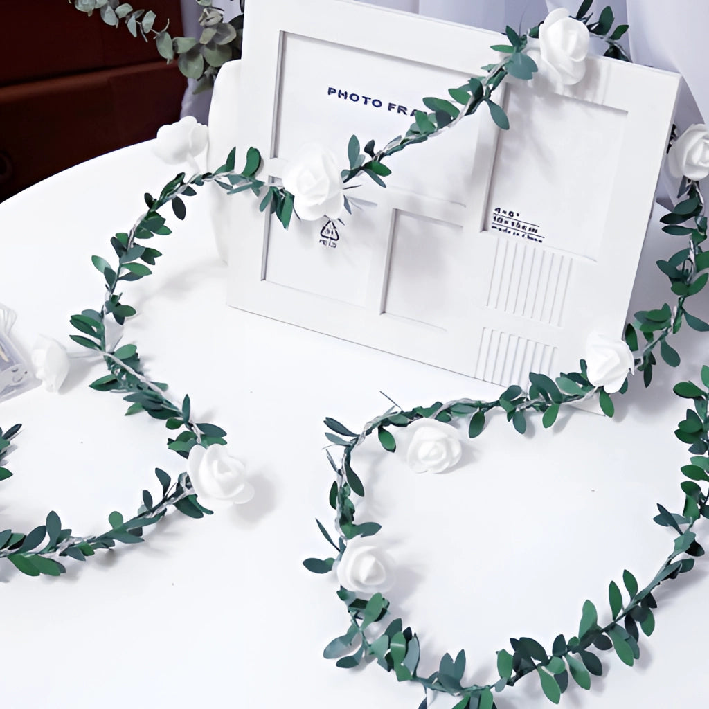 Battery operated LED garland with rose flower string lights on a green twig-like wire.