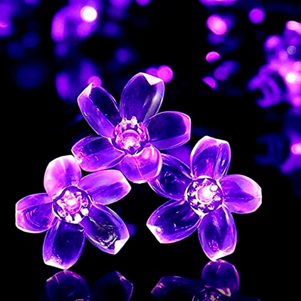 Cherry purple Solar Flower Garden LED light strips illuminating a garden with vibrant purple and magenta flowers.