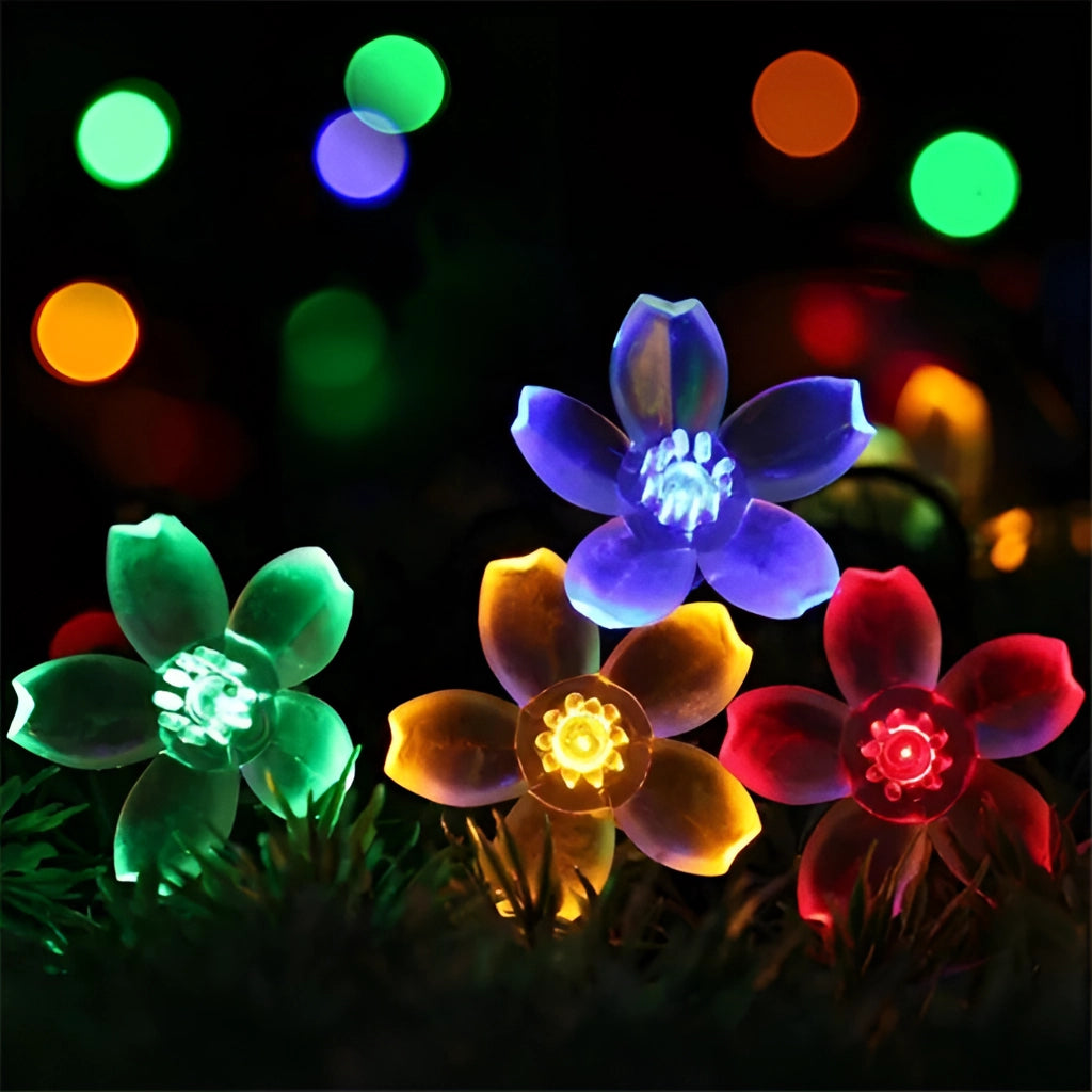 Solar Flower Garden LED Light Strips - Cherry Colorful, featuring vibrant, multicolored flowers, illuminating a garden area with bright, electric blue and various other hues.