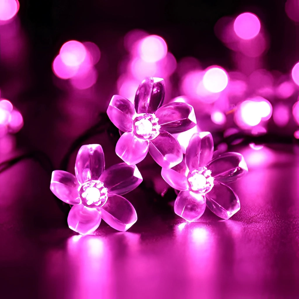 Solar Flower Garden LED Light Strips in cherry pink illuminating a garden with vibrant pink and magenta flowers.