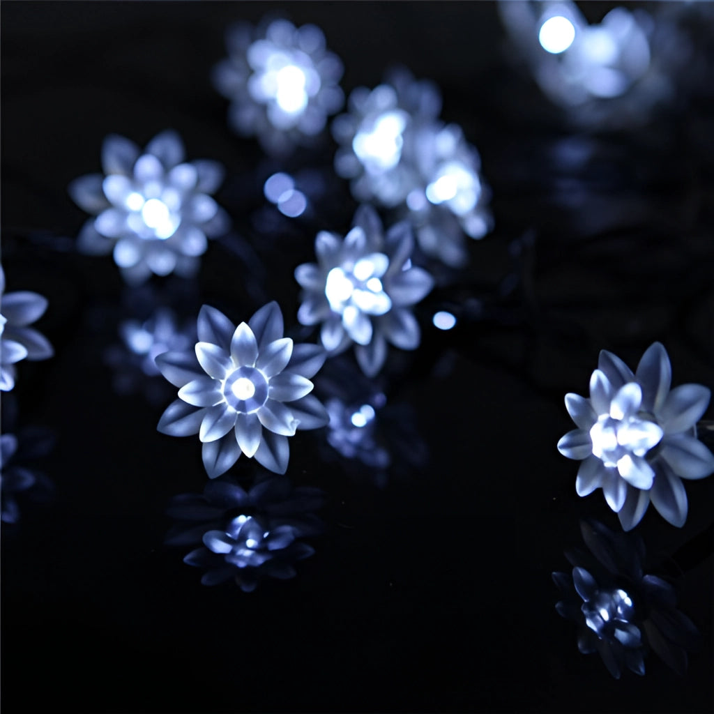 White Lotus Solar Flower Garden LED Light Strips illuminating a garden with vibrant colors at night.