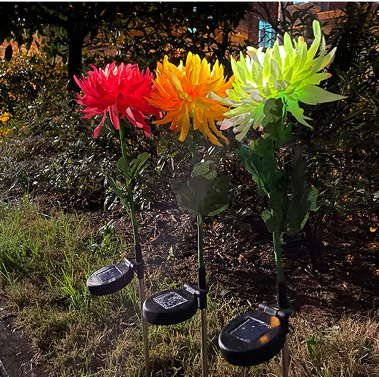 Solar LED Crown Imperial Flower Lights in a garden setting, showcasing vibrant petals and lush green leaves, with a flowerpot visible amidst the grass and landscape.