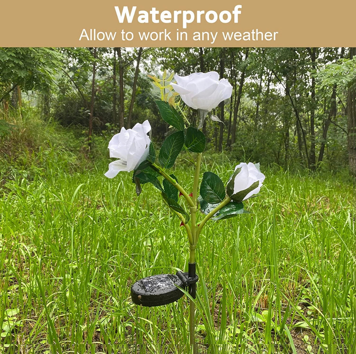 White Solar LED Rose Lights in a twin pack illuminating a garden landscape with petals and leaves, placed amidst grass and other terrestrial plants.