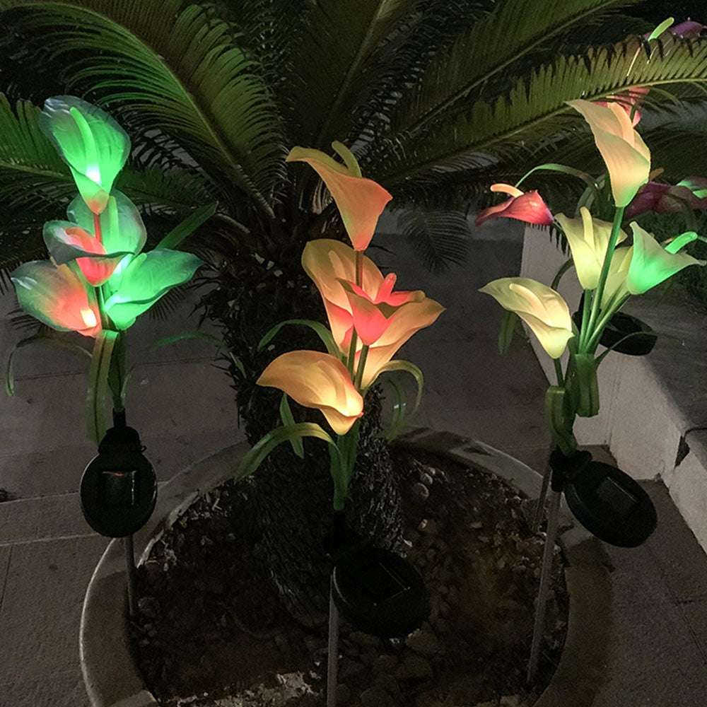 Set of 4 Solar Lily Garden Lights with Multi-color LEDs placed in flowerpots among other plants and flowers.