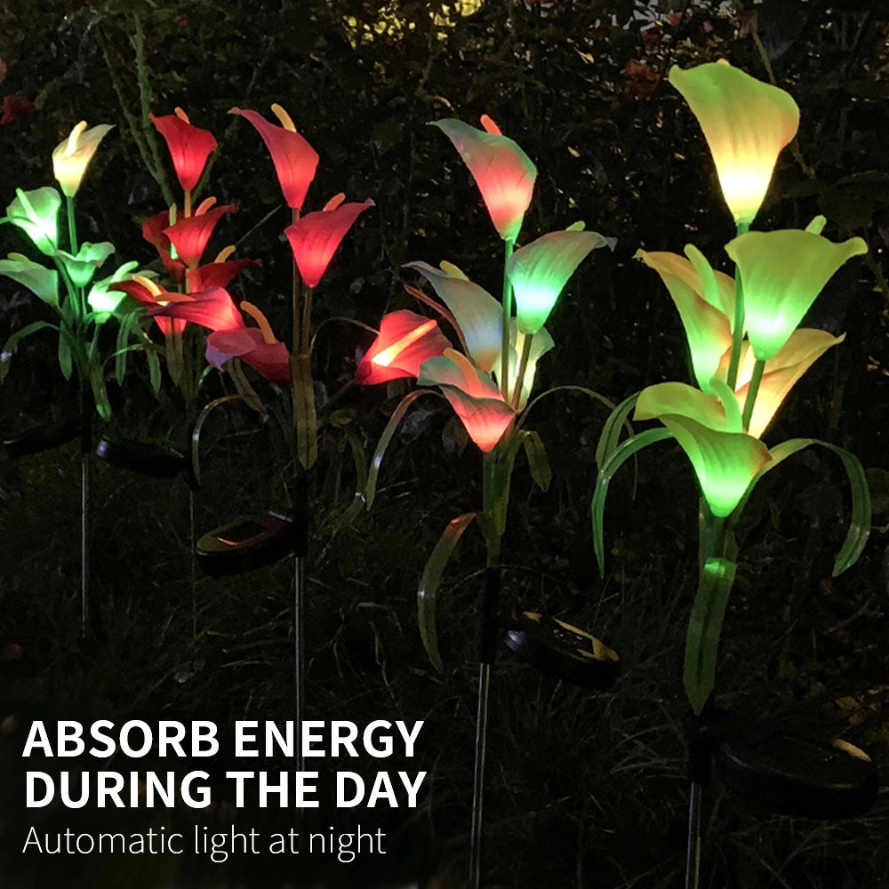 Set of four solar lily garden lights with multi-color LEDs, displayed among lush green plants and vibrant flowers in a garden setting.