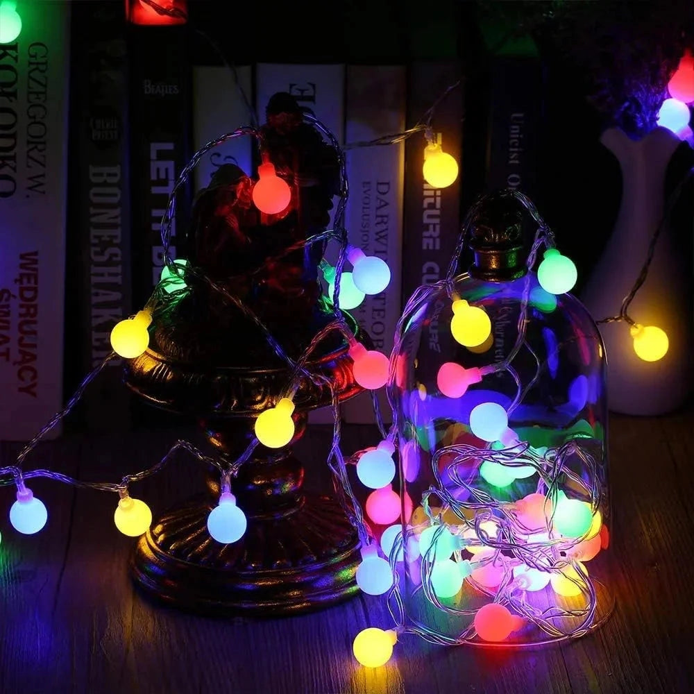 Solar powered waterproof outdoor LED string lights in RGB colors, 72 feet long with 200 LEDs, illuminating a garden area with vibrant colors, suitable for holiday and event decorations.