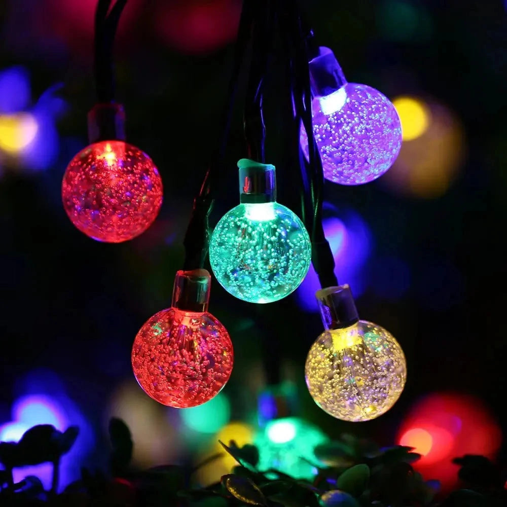 Solar string lights with IP65 waterproof RGB and white LEDs, featuring a long battery life, displayed in various colors including purple and magenta, illuminating in a dark environment.
