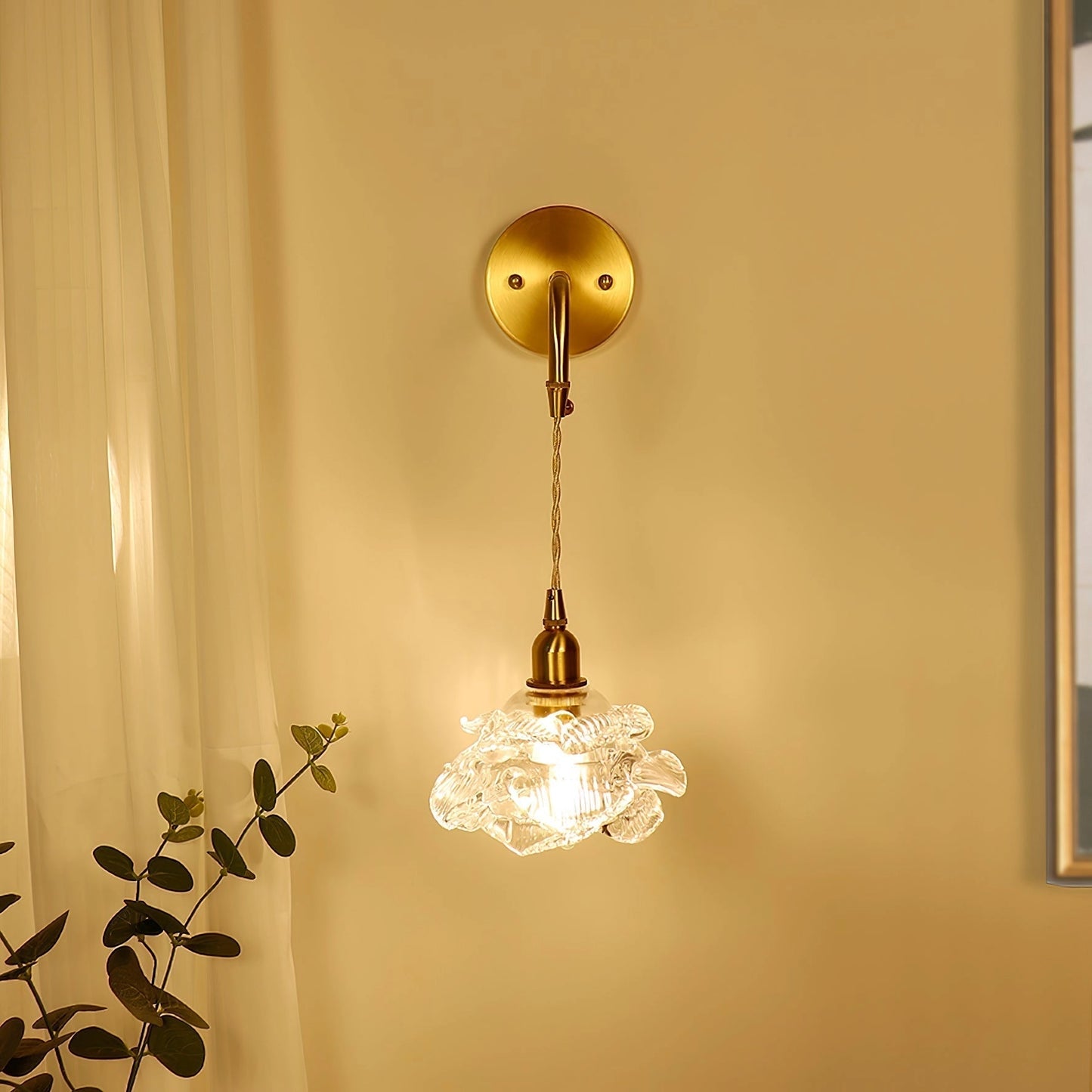Vintage brass wall light with rose glass shade, elegant wall sconce illuminating an interior room with amber tones and wooden accents.