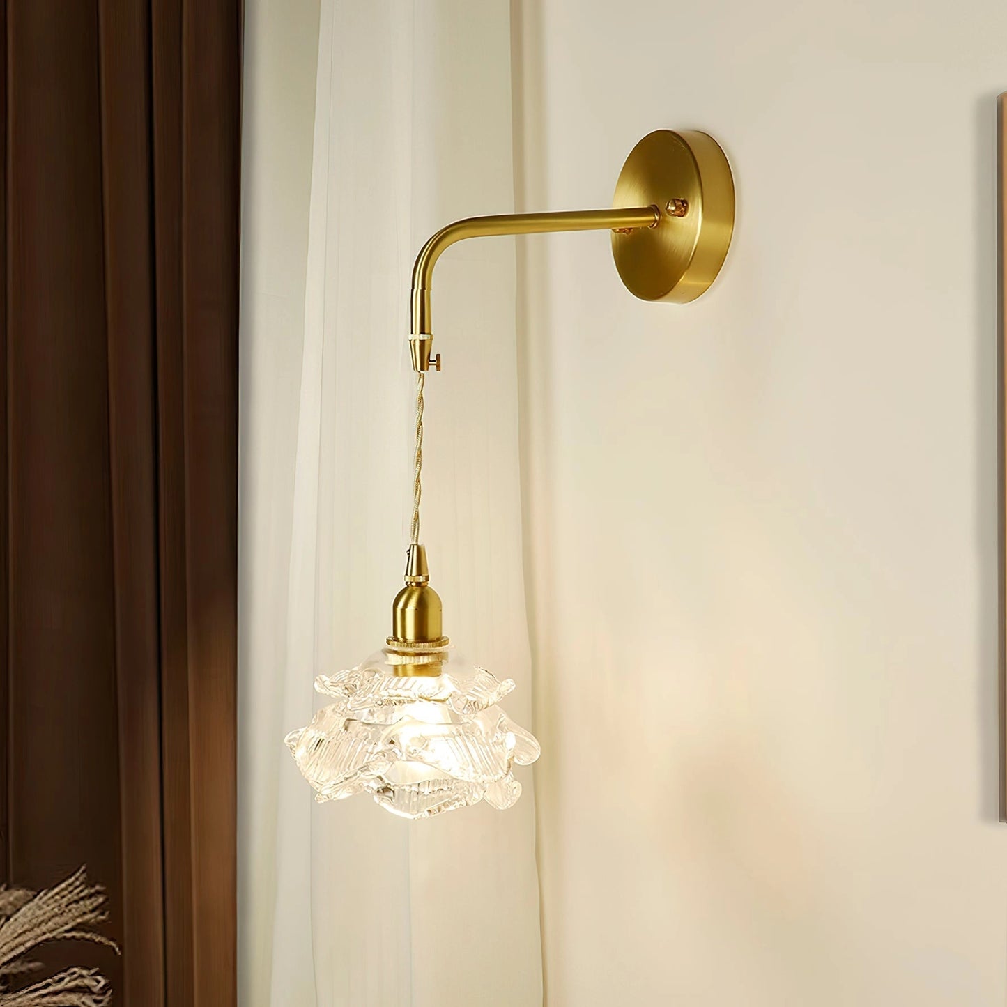Vintage brass wall light with rose glass shade, elegant wall sconce featuring gold and amber tints, mounted on wood panel background.