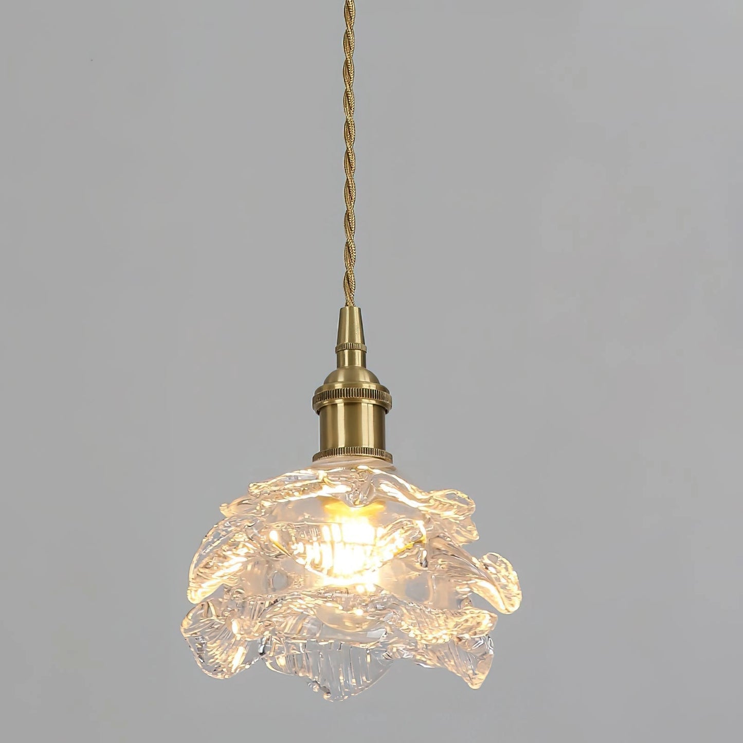 Vintage brass wall light with rose glass shade, elegant wall sconce with amber tones and intricate ornament design, featuring a circular metal fixture.