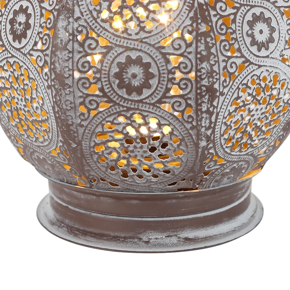Vintage Moroccan metal lantern with intricate patterns and battery power, showcasing a symmetrical and artistic design.