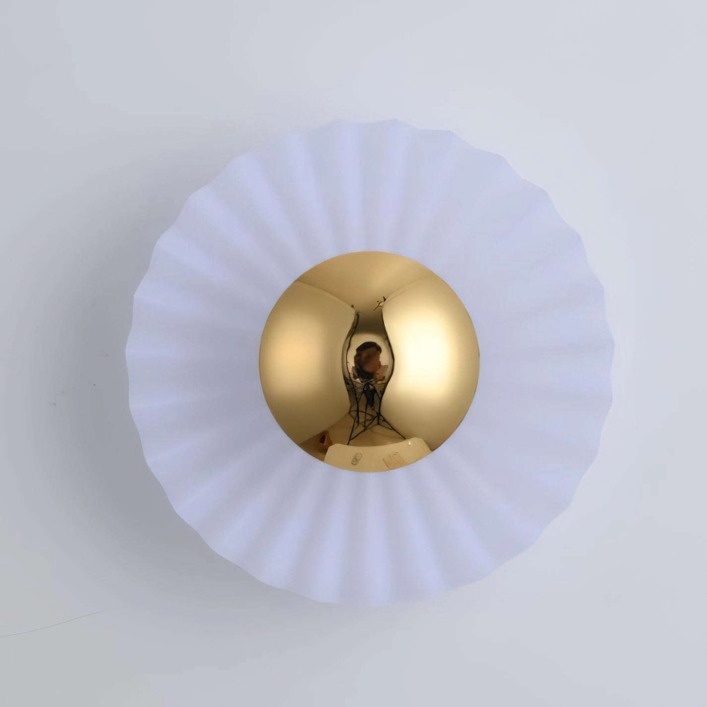Modern wall lamp with artistic design, featuring a circular metal frame and elegant wood accents, mounted on a ceiling.