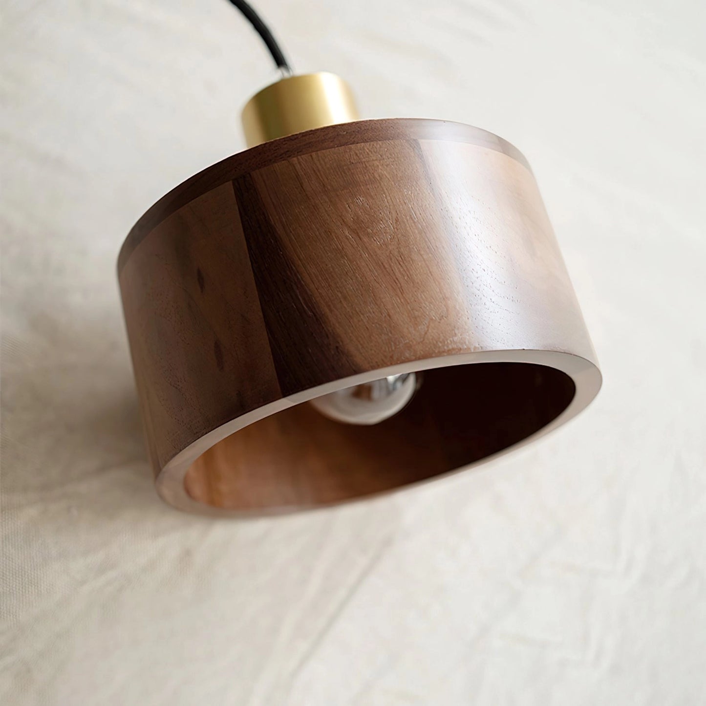 Walnut wood pendant lamp inspired by Japanese woodworking, featuring a rectangular wooden frame with metal accents, hanging from the ceiling as a stylish light fixture.