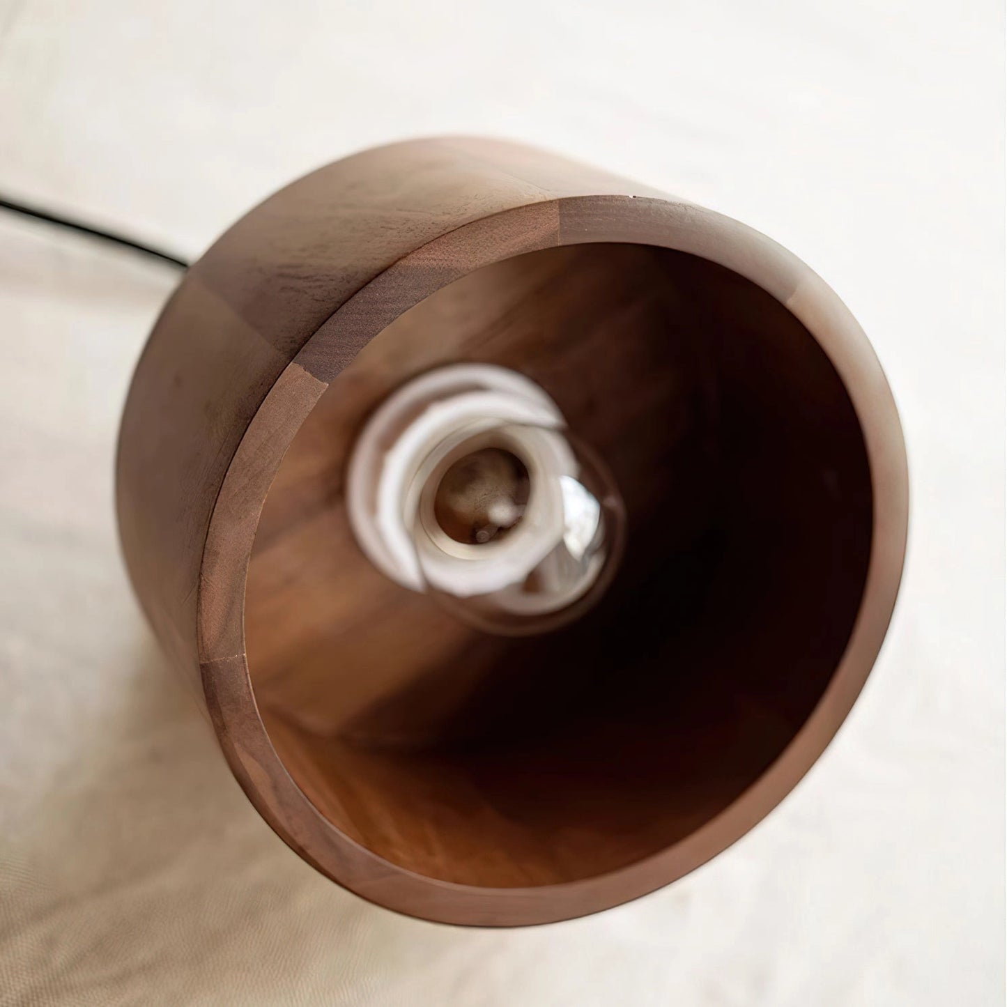 Walnut wood pendant lamp with a circular design, showcasing Japanese woodworking inspiration, hanging from the ceiling.