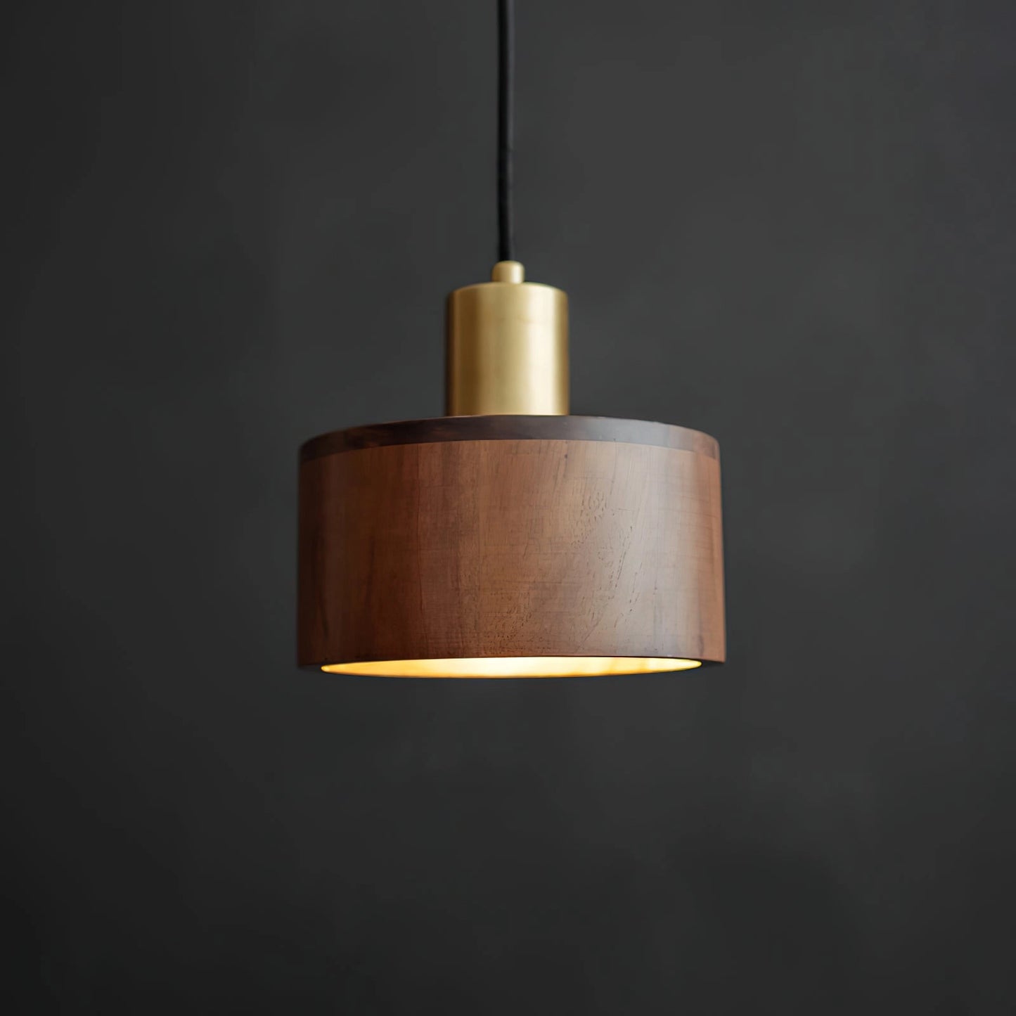 Walnut wood pendant lamp with Japanese woodworking inspiration, featuring a rectangular wooden lampshade and metal accents, hanging from the ceiling.