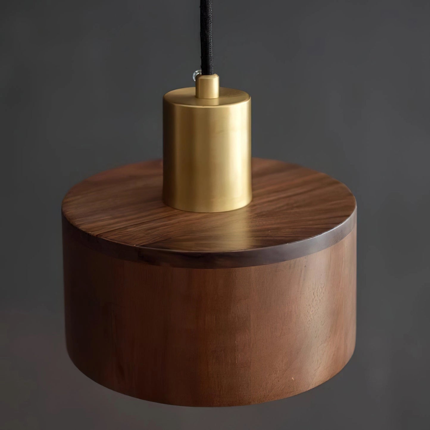 Walnut wood pendant lamp inspired by Japanese woodworking, cylindrical ceiling fixture with a smooth circular design.