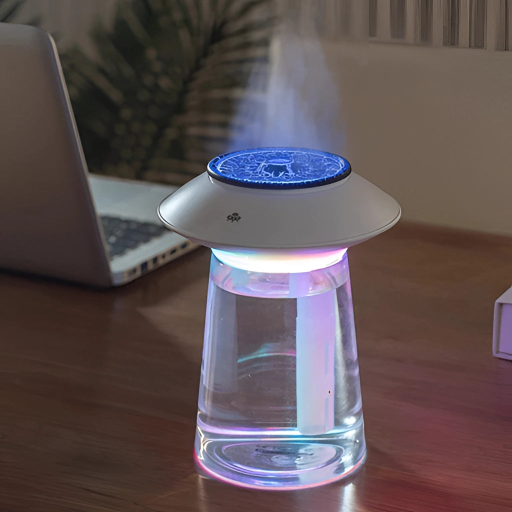 USB rechargeable ultrasonic mist maker with 760ml capacity next to a laptop, emitting mist, ideal for interior use.