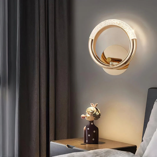 Luxurious metallic rotatable wall lamp, mounted on a wooden wall, reflecting off a mirror, with interior design elements such as a table, curtain, and window in the background.