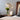 Adjustable Nordic Style Wall Lamp with Rotatable Design mounted on a wall above a wooden table, decorated with a plant in a vase, showcasing a modern interior design.