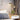 Adjustable Nordic Style Wall Lamp with Rotatable Design mounted on a wooden wall, illuminating a nearby table with a plant on it, showcasing a modern interior design setting.