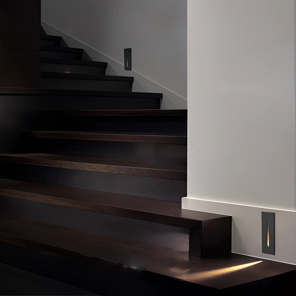 Modern black and white rectangular wall light fixture installed on wooden stairs, suitable for indoor and outdoor use, made of waterproof aluminum with IP65 rating.