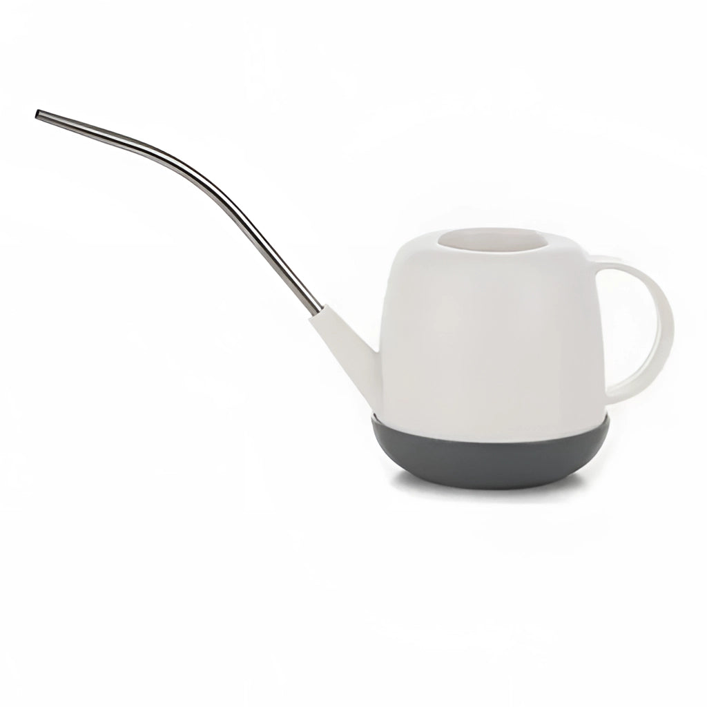 Ivory-colored modern and functional garden watering can on a table.