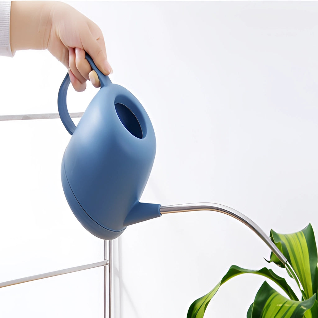 April Showers Garden Watering Can in a modern design, surrounded by various houseplants.