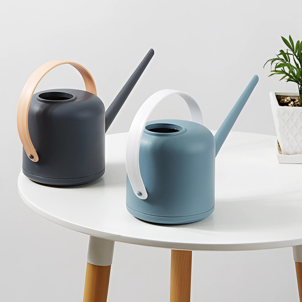Modern and functional April Showers garden watering can, displayed with houseplants and flowerpots in a white and grey color scheme.