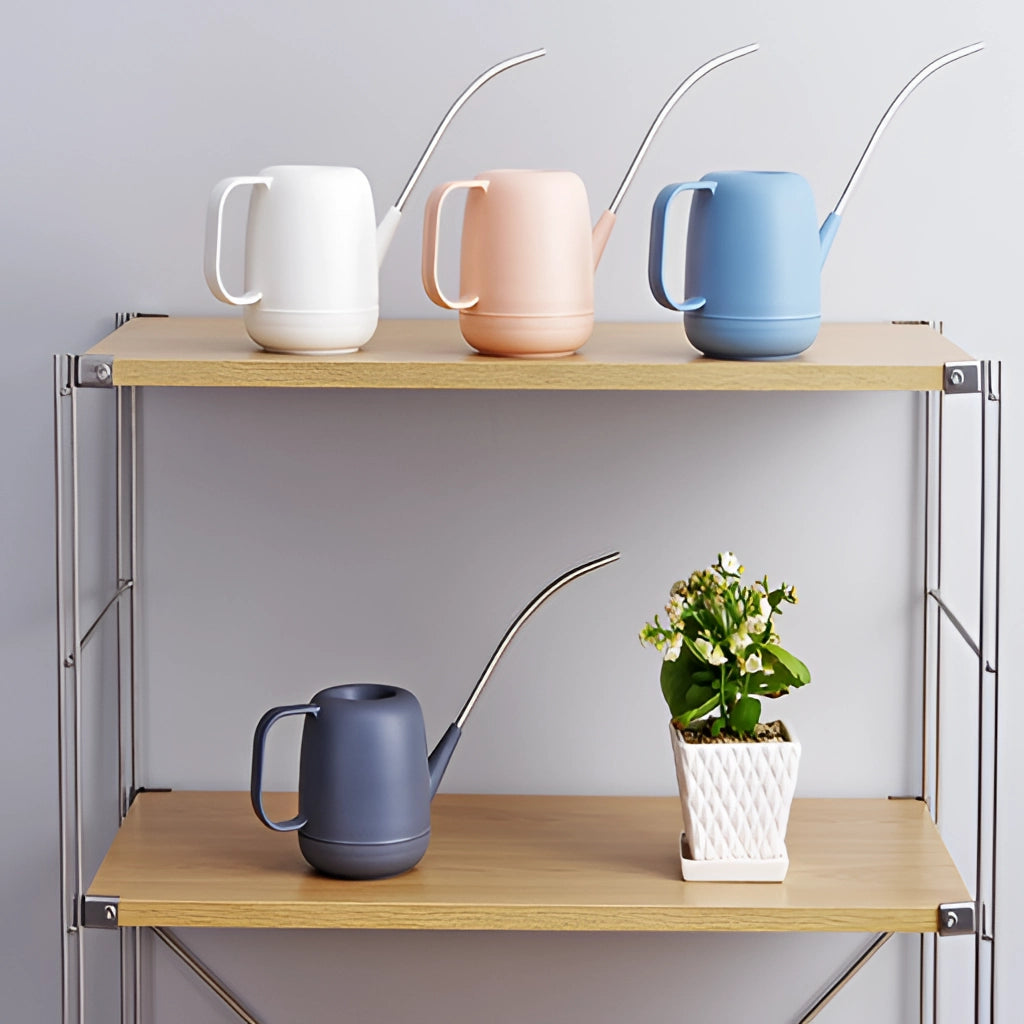 Modern and functional April Showers garden watering can placed on a table surrounded by potted houseplants and tableware.