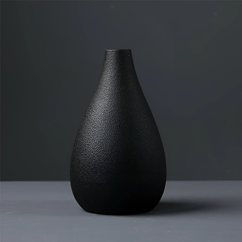 Black ceramic vase with a cone shape and smooth finish, suitable for home and garden decoration.