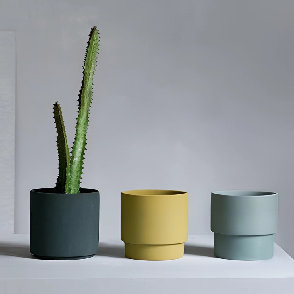 Bright porcelain stackable flowerpot planters with various houseplants displayed in cylindrical and rectangular shapes.