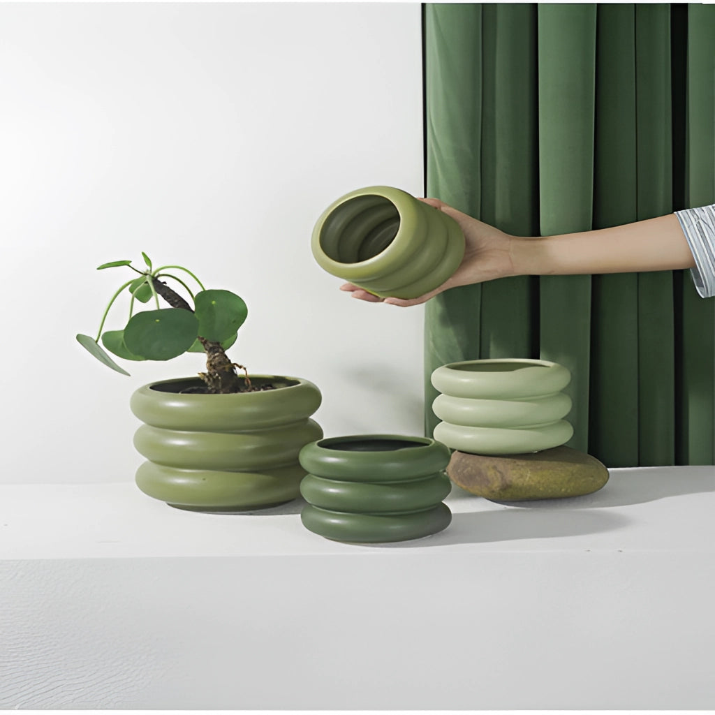 Round ceramic Bubble Glass planter vase with a houseplant on a wooden shelf, featuring interior design elements.