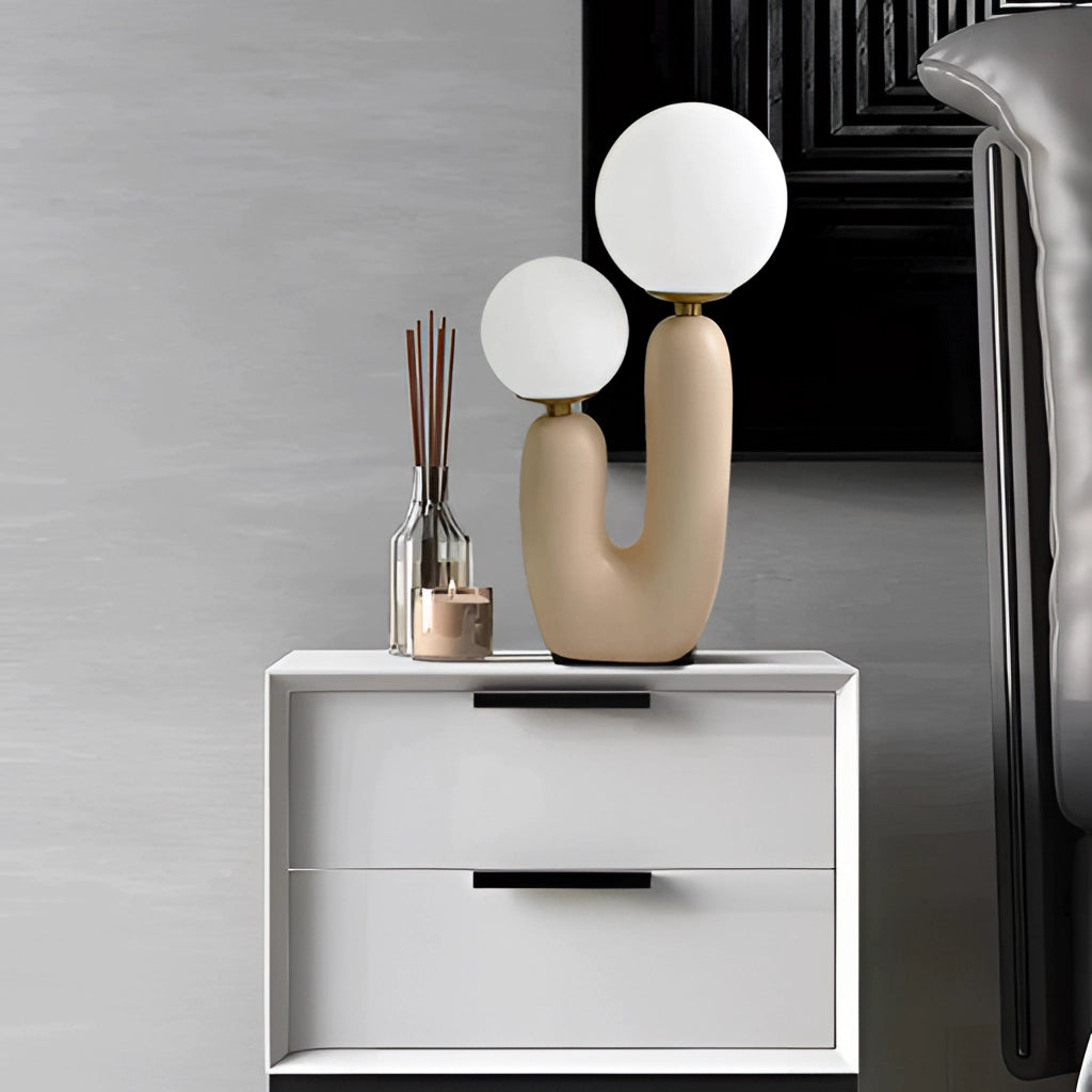 Cactus Design Table Lamp with Milk Glass Globes and LED Innovation on a wooden table near a wall with cabinetry in the background.