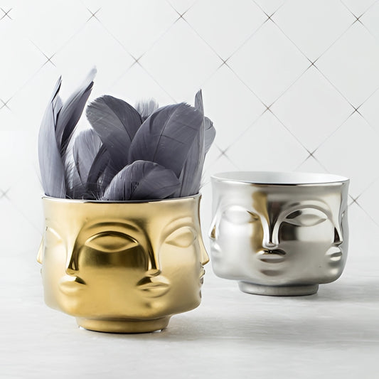 A modern succulent planter with a ceramic face design, featuring intricate facial expressions, resembling a piece of serveware or drinkware.