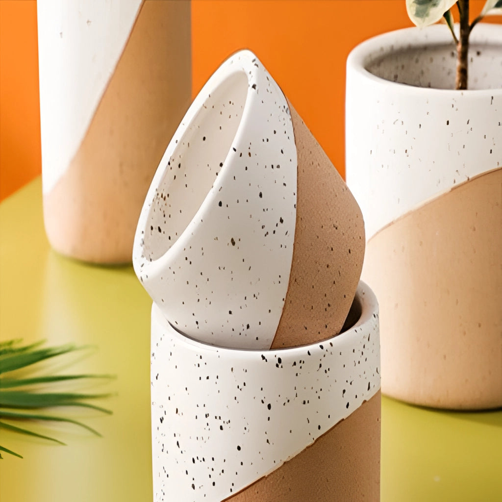 Small, medium, and large ceramic flowerpots in linen color arranged on a table, showcasing their smooth, porcelain finish and elegant design.