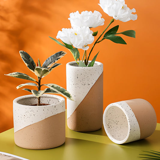 Small, medium, and large ceramic flowerpots in linen color with yellow flowering houseplants.