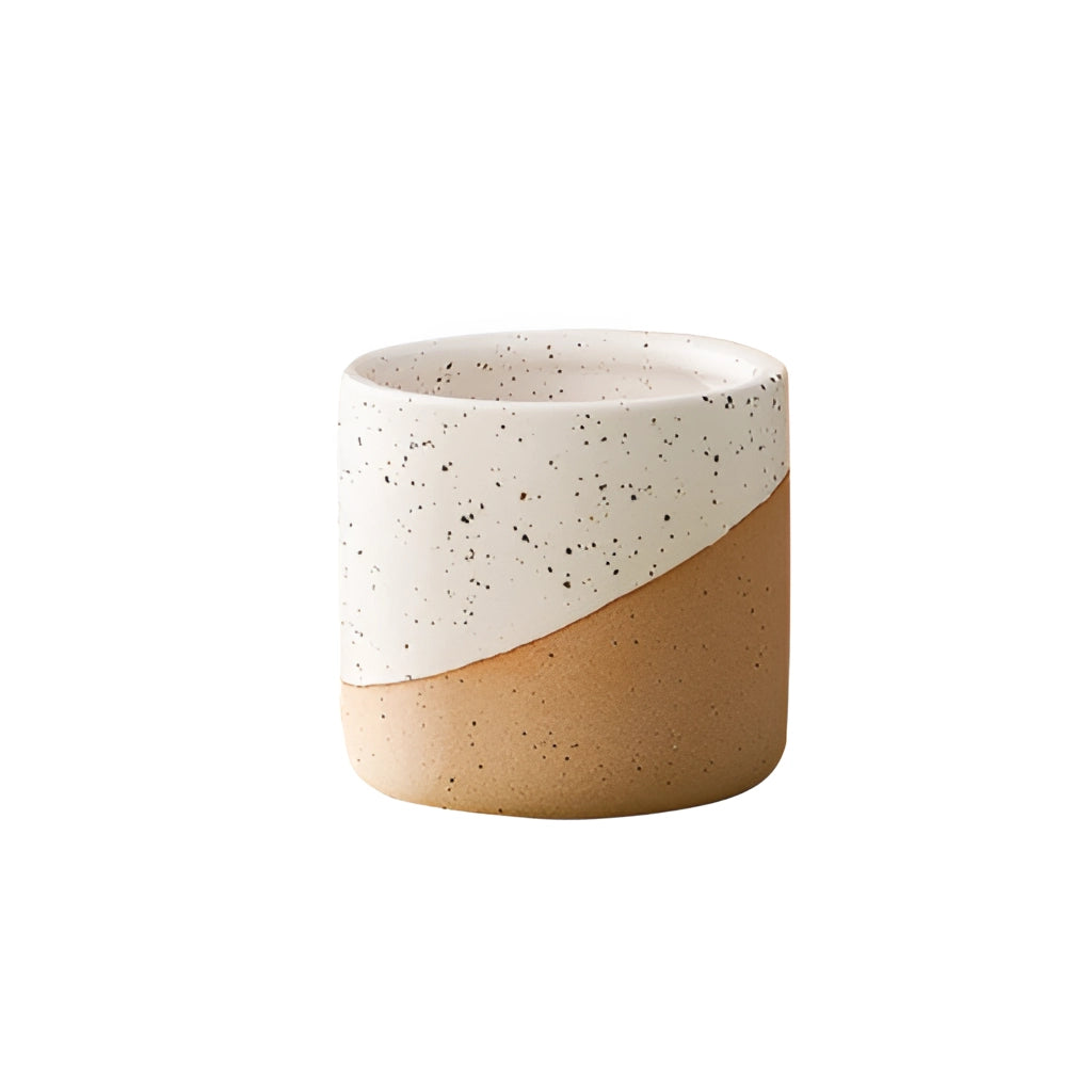 Small ceramic flowerpot in linen color, resembling a cylindrical pottery piece, placed on a tabletop.