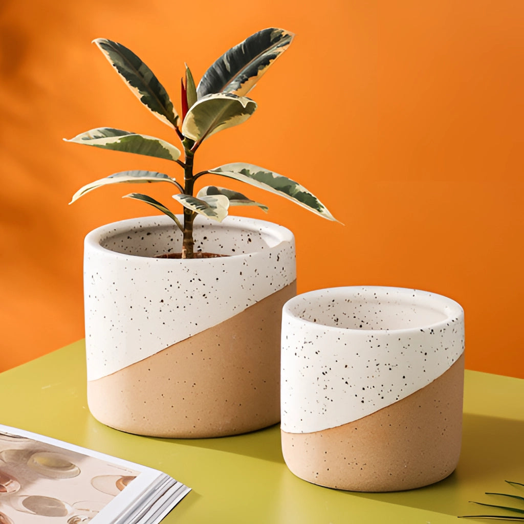 Small, medium, and large ceramic flowerpots in linen color, each holding a houseplant.