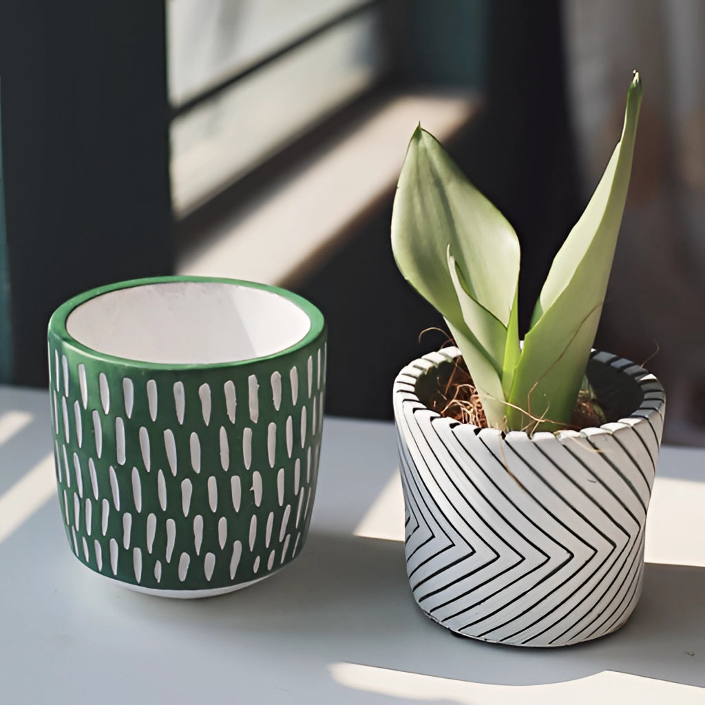 Hand-painted ceramic planters with textured designs, featuring vibrant colors and patterns, displayed with green houseplants.