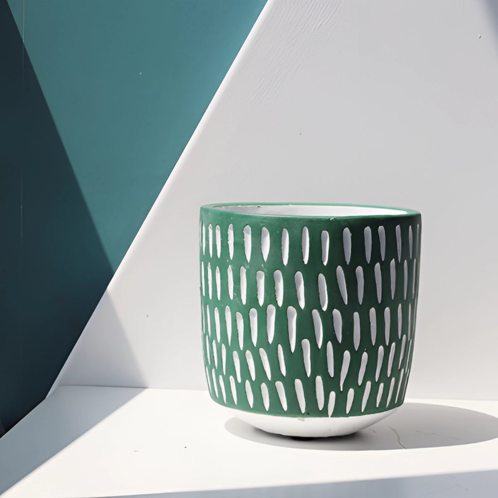 Hand-painted ceramic planters with textured designs displayed on a table.