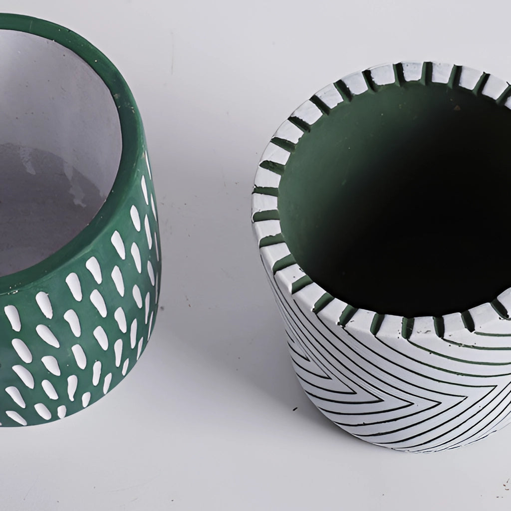 Hand-painted ceramic planters with textured designs in various patterns and colors, displayed on a surface.