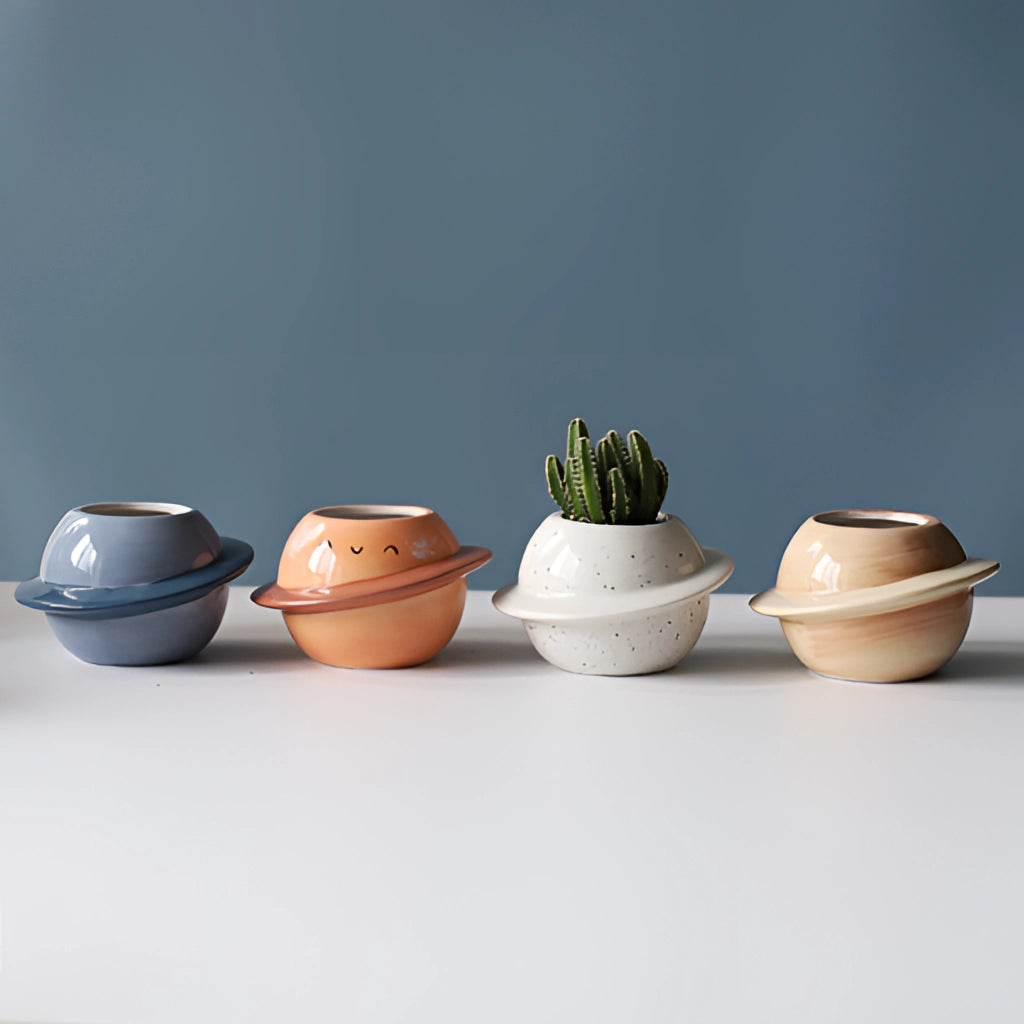 Ceramic Planet Plant Pot with Astral Galaxy Design featuring a round, glossy finish, suitable for holding plants, displayed on a surface.