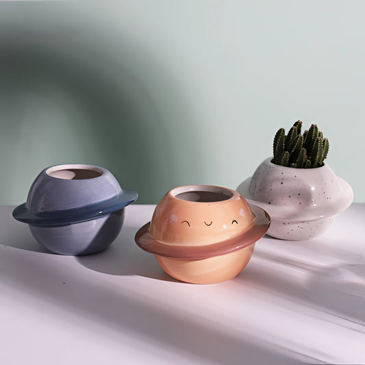 Ceramic planet-shaped plant pot with astral galaxy design, featuring a smooth porcelain finish, displayed with no plant inside.