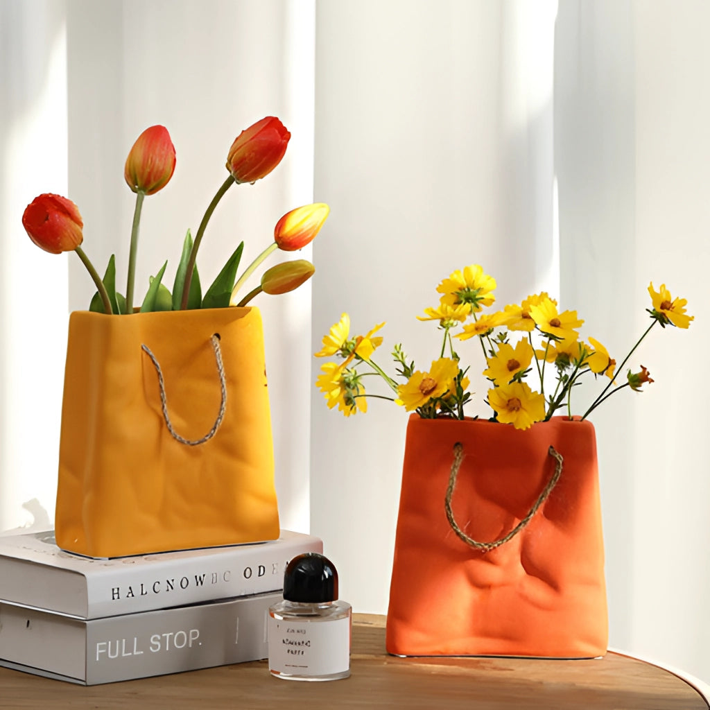 A ceramic vase with a shopping basket design, filled with an arrangement of orange and yellow flowers, placed in an interior setting.