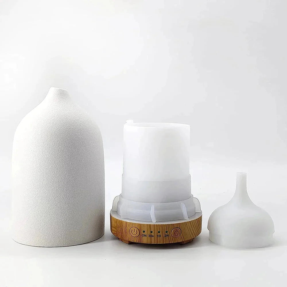 Ceramic wood grain aromatherapy diffuser with 7-color night light, cylindrical design, placed on a surface, emitting a soft glow.