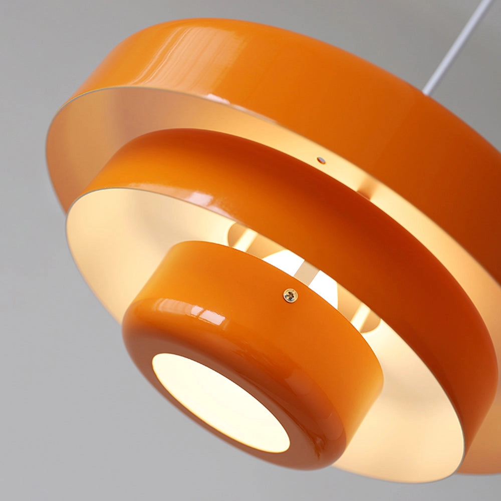 Modern metal pendant lamp with linked circle design and amber lighting.