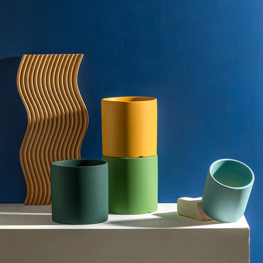 Colorful ceramic planter and saucer set featuring a rectangular and cylindrical design on a wooden surface.