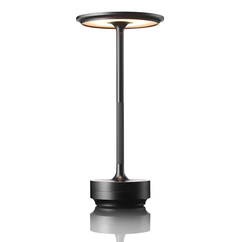 Sleek black contemporary LED desk light with wireless ambiance, rechargeable battery, and touch control, shown in a still life setting.
