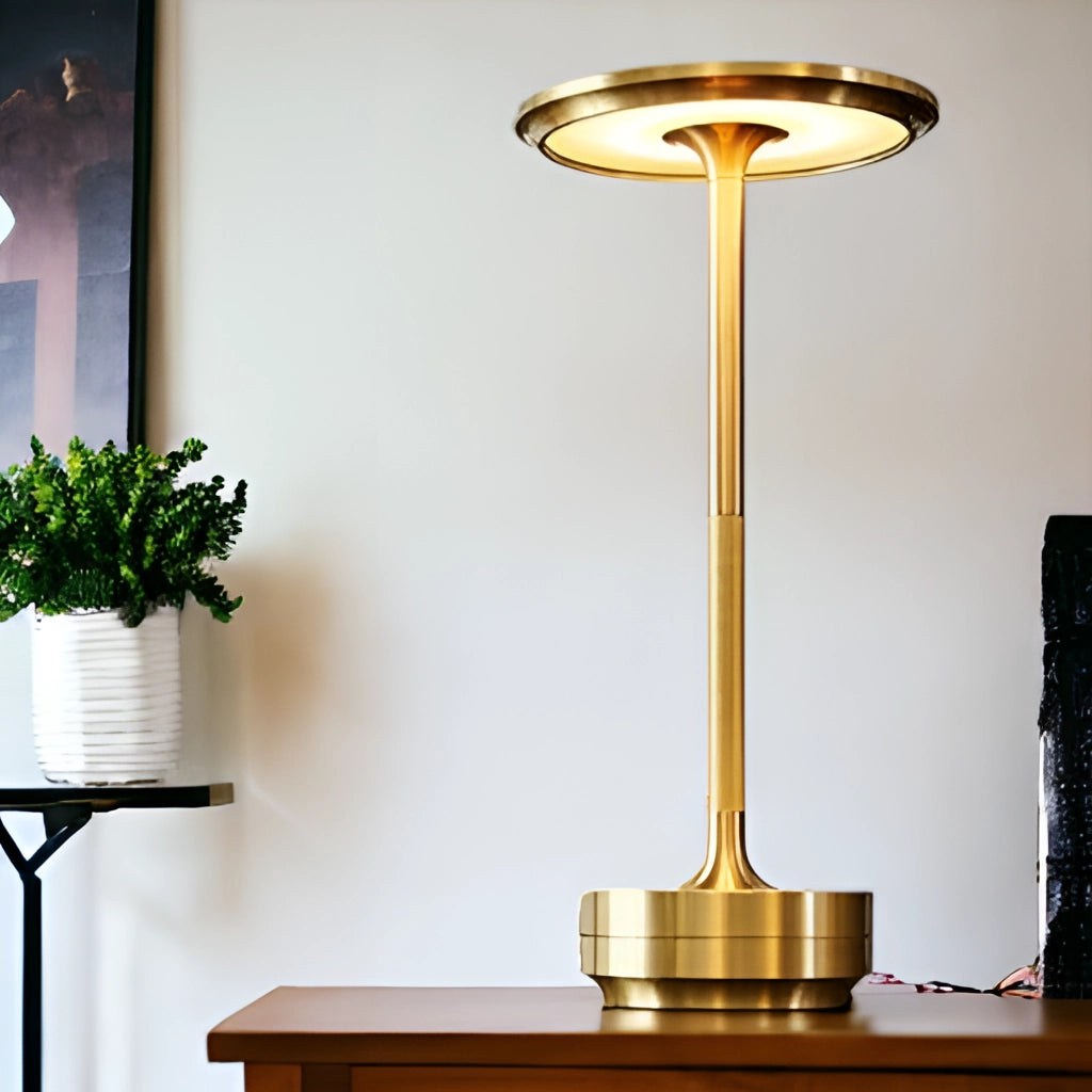 Contemporary LED desk light with touch control on a wooden table next to a houseplant in a flowerpot, emitting a warm yellow light.