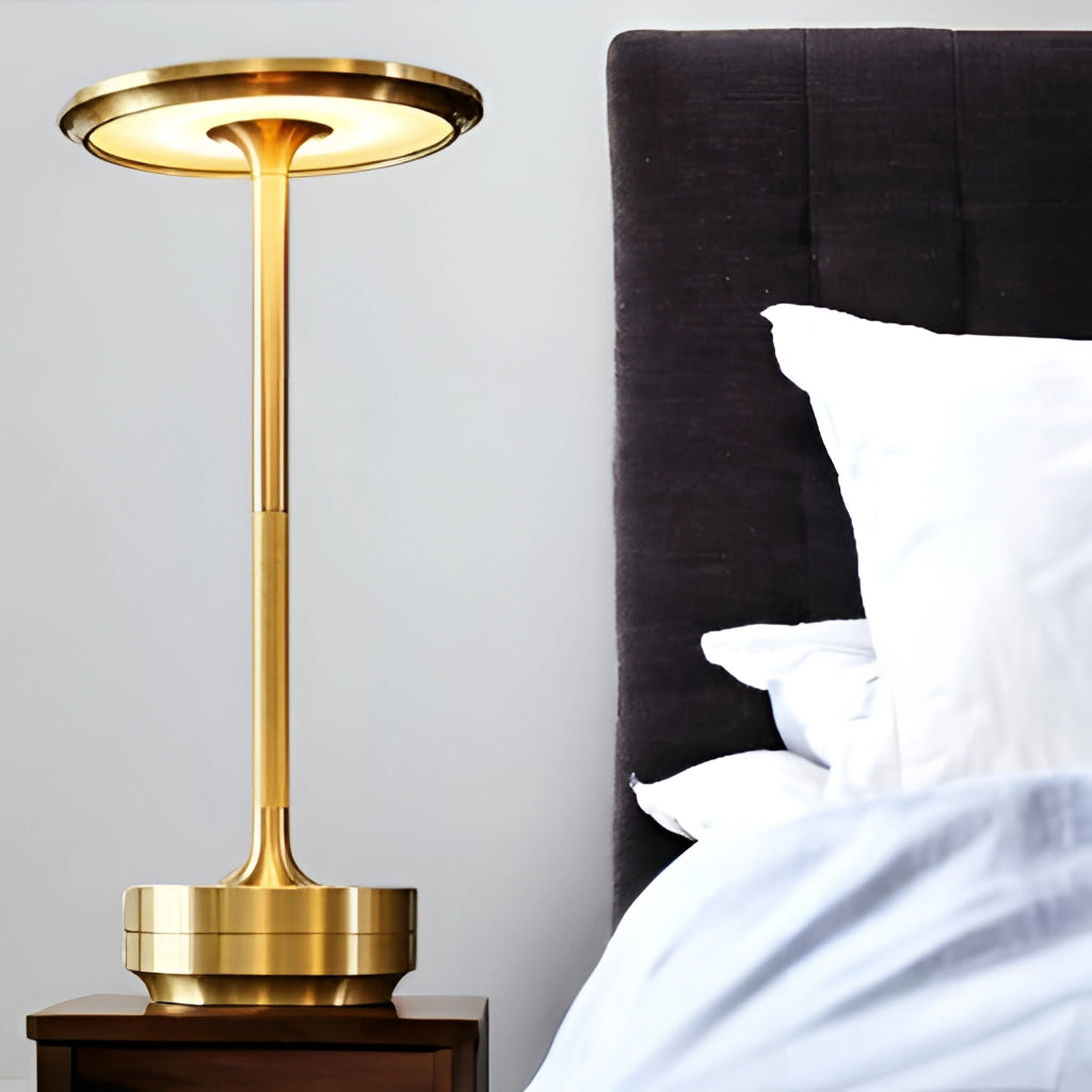 Contemporary LED desk light with wireless ambiance, rechargeable touch control, and energy-saving features, placed on a wooden surface next to a pillow and linens.